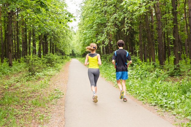 Courir ensemble - amis faire du jogging dans le parc