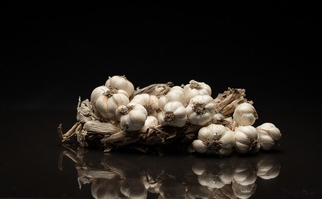 La couronne d'ail parfumée se trouve sur fond sombre Agriculture et élevage