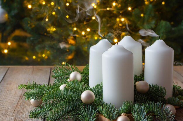 Couronne d'avent avec quatre bougies blanches, des branches de sapin sur fond de bois, dimanche