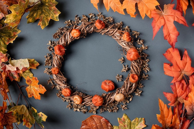 Couronne décorative d'automne de branches et de feuilles rouges sur fond gris copie espace plat