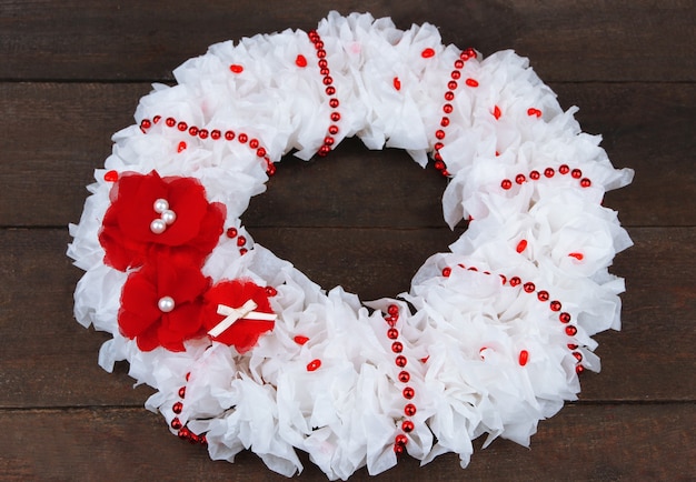 Couronne décorative avec des fleurs sur fond de bois