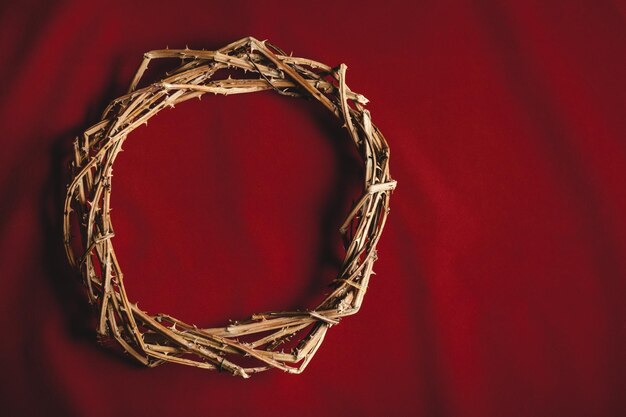 Photo une couronne d'épines sur un tissu rouge.