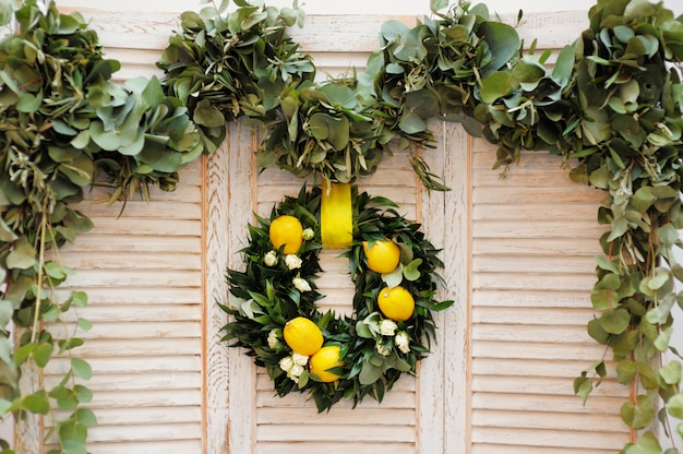 Couronne de feuilles de laurier, de roses et de citrons en décoration sur bois