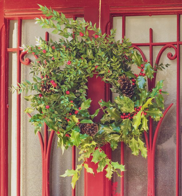 Couronne de houx de Noël sur une porte rouge