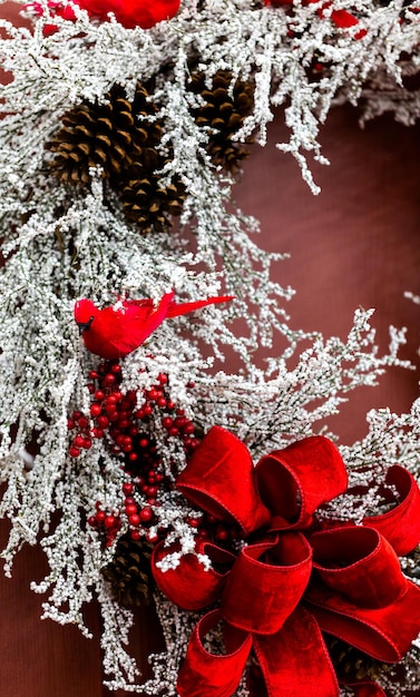 Couronne de Noël blanche et rouge sur la porte d'entrée.