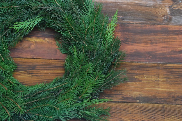 Couronne de Noël de branches de sapin vert sur un fond en bois avec espace de copie