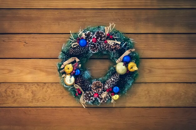 Couronne de Noël de cônes, branches d'épinette et baies, décorations du nouvel an. belle couronne d'épinette avec des cônes, des boules et des fruits.