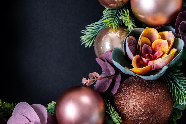 Couronne de Noël avec décoration de fleurs sur fond noir. mise à plat