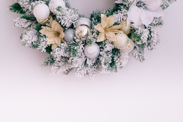 Photo couronne de noël enneigé sur un mur blanc