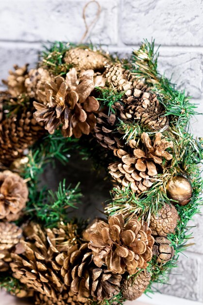 Couronne de Noël faite de branches de sapin et de cônes naturels Dans le contexte d'un mur de briques grises Nouvel An et vacances d'hiver Décor de Noël Gros plan