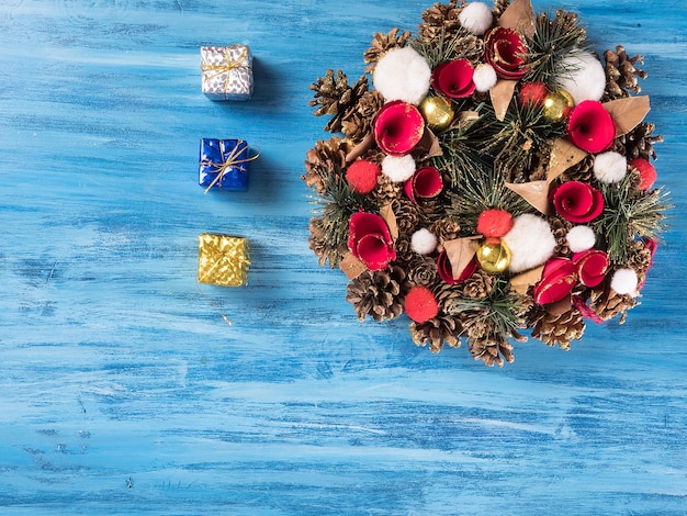 Couronne de Noël faite à la main sur un fond en bois. Lumières festives de guirlande.