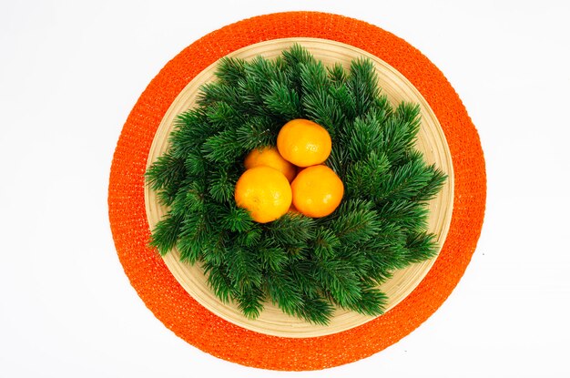 Couronne de Noël avec mandarines et assiette. Studio photo.