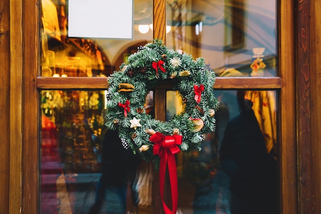 Couronne de Noël sur la porte en bois en verre du magasin Décoration de Noël ou du nouvel an