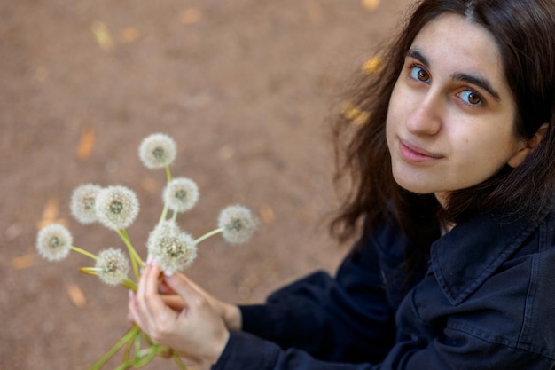 Une couronne de pissenlits blancs Instructions étape par étape Femme tenant un bouquet de pignon blanc aéré