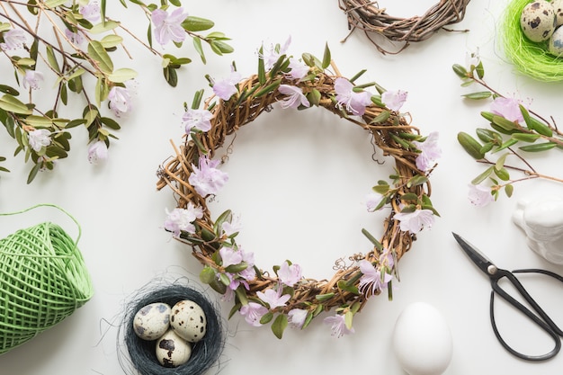 Couronne de printemps avec des fleurs sur la lumière. Mise à plat créative. Décor fait main.