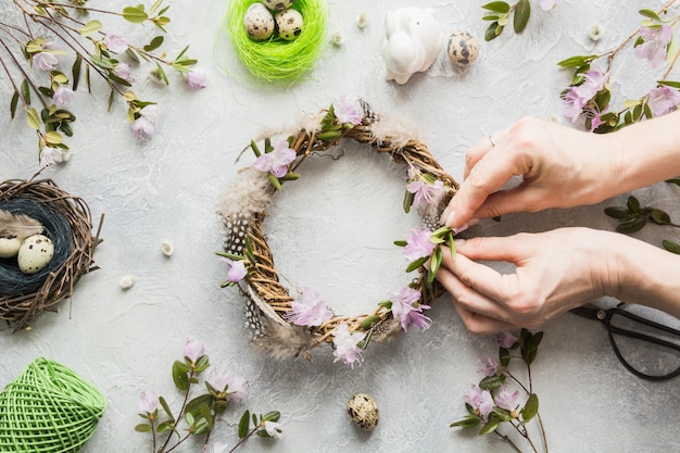 Couronne de printemps avec des fleurs sur la lumière. Mise à plat créative. Vue de dessus. Décor fait main. Femme décorée.