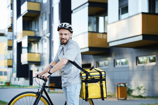 Courrier express de livraison de nourriture avec sac isotherme debout avec vélo