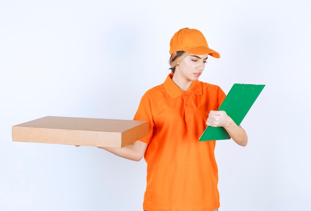 Courrier féminin en uniforme orange tenant une boîte en carton et une liste de clients verts