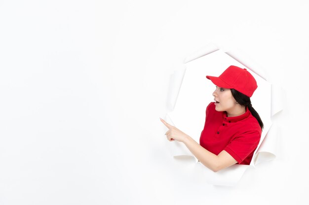 Courrier féminin en uniforme rouge pointant vers quelque chose sur blanc