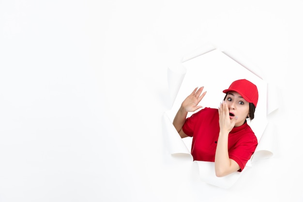 Courrier féminin en uniforme rouge regardant ci-dessus sur blanc