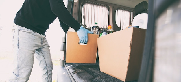 Photo le courrier prend la boîte écologique en carton avec les produits de l'épicerie de la camionnette