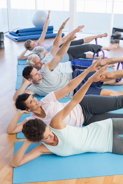 Cours de conditionnement physique étirement des jambes et des mains dans la rangée