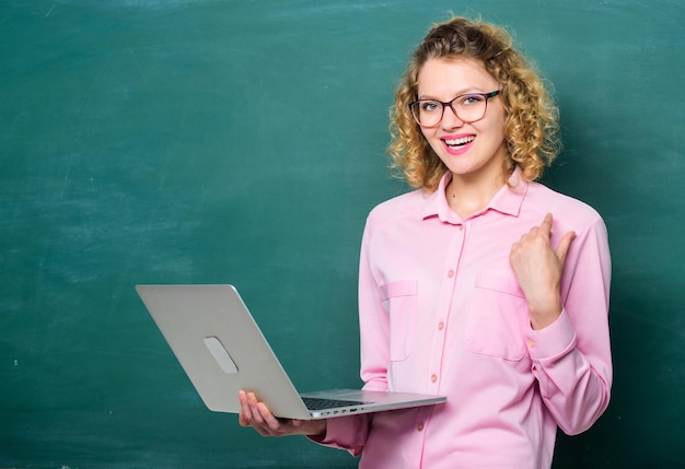 Cours d'enseignement en ligne. Concept de scolarité en ligne. Cahier de l'enseignant à la recherche d'informations sur l'arrière-plan du tableau. École en ligne. Ordinateur portable femme surfer sur internet. Informatique et programmation. Travail à distance.