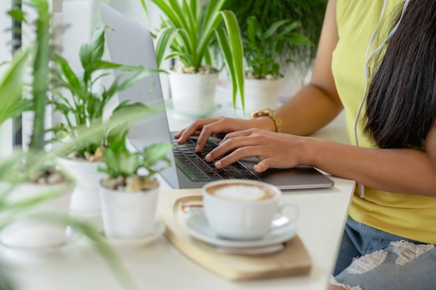 Cours en ligne, étudiant écrit sur un ordinateur portable tout en étudiant à la maison