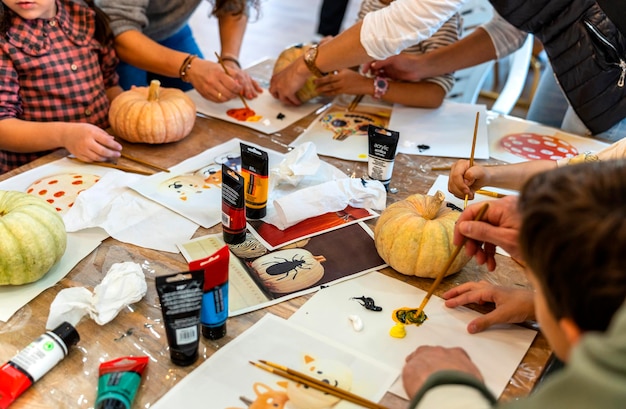 Photo cours de peinture pour enfants journée de peinture avec les parents en classe peignant des citrouilles