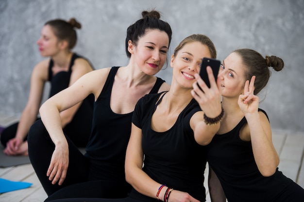 Cours de yoga de joyeux amis de la génération Y prend un selfie