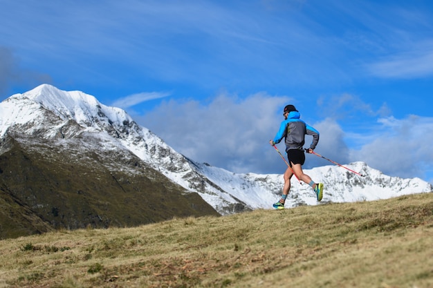 Course de montagne d'endurance. un homme avec des bâtons en descente