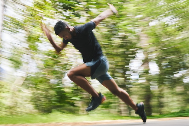 Photo course à pied et flou de l'homme en forêt pour un entraînement marathon et un entraînement cardio course sportive et athlète avec vitesse pour des performances de bien-être et d'endurance pour les défis dans la nature