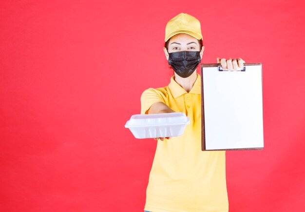 Coursière en uniforme jaune et masque noir tenant un colis à emporter et présentant la liste des signatures