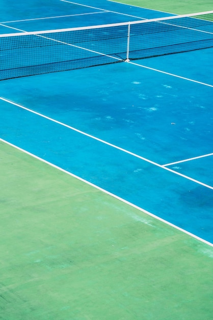 Court de tennis désert avec greentrees en arrière-plan dans un parc public un matin d'été ensoleillé