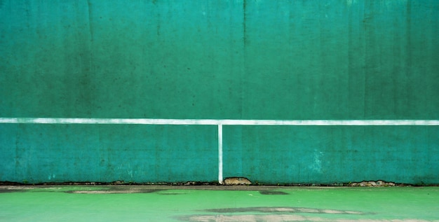 Court de tennis vert et mur pour la pratique