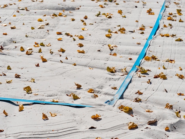 Photo court de volley-ball vide à l'intérieur de la saison d'automne feuilles sèches sur le sable
