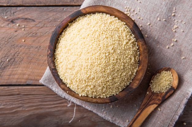 Couscous cru dans un bol en bois sur la table