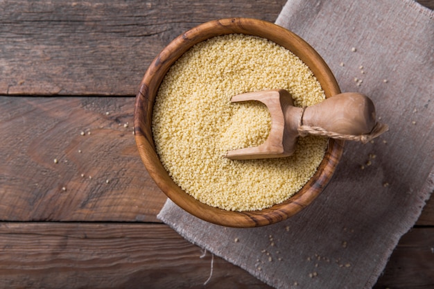 Couscous cru dans un bol en bois sur la table