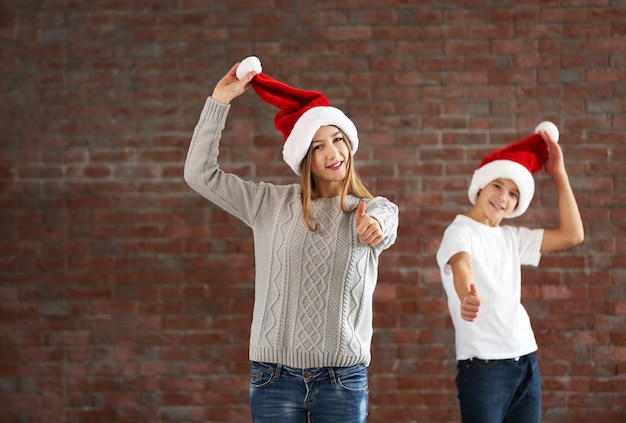 Les cousins heureux s'amusent sur le fond de mur de briques