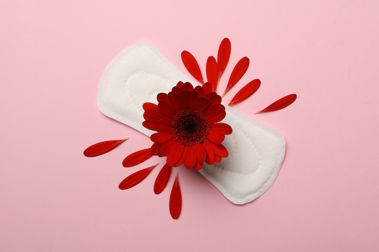 Photo coussin sanitaire avec gerbera sur surface rose