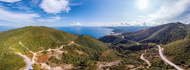 Coût de la mer Égée de la Grèce, route sinueuse, collines couvertes de verdure luxuriante, vue depuis le drone