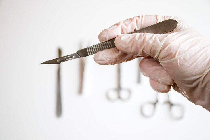 Photo couteau de chirurgie sur le fond blanc studio de tournage équipement d'opération gant blanc