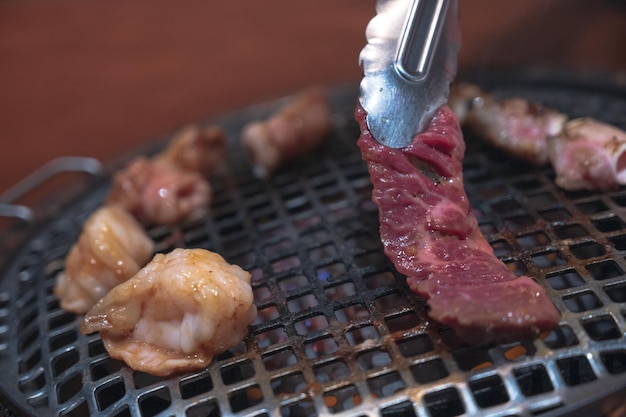 Un couteau coupant un morceau de viande sur un gril