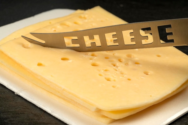 Couteau avec l'inscription Fromage Texture de fromage Radomer avec gros plan sur fond noir