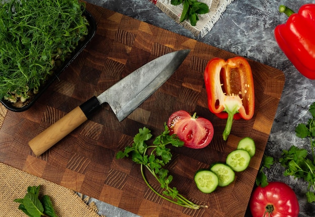 Couteau japonais professionnel sur planche à découper et légumes frais