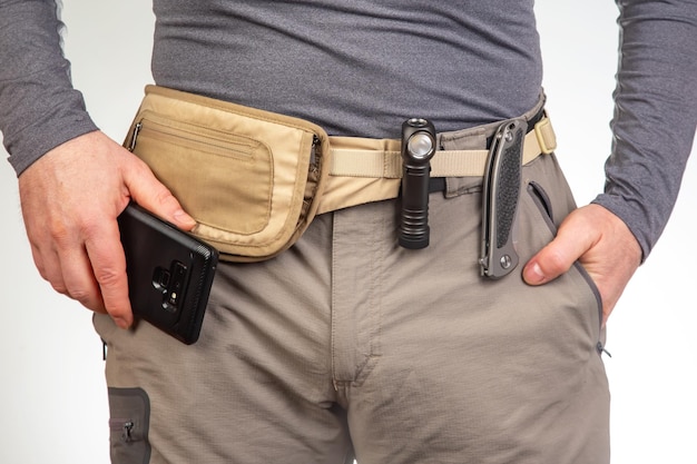 Photo couteau et lampe de poche avec des clips sur la ceinture des pantalons de trekking articles edc