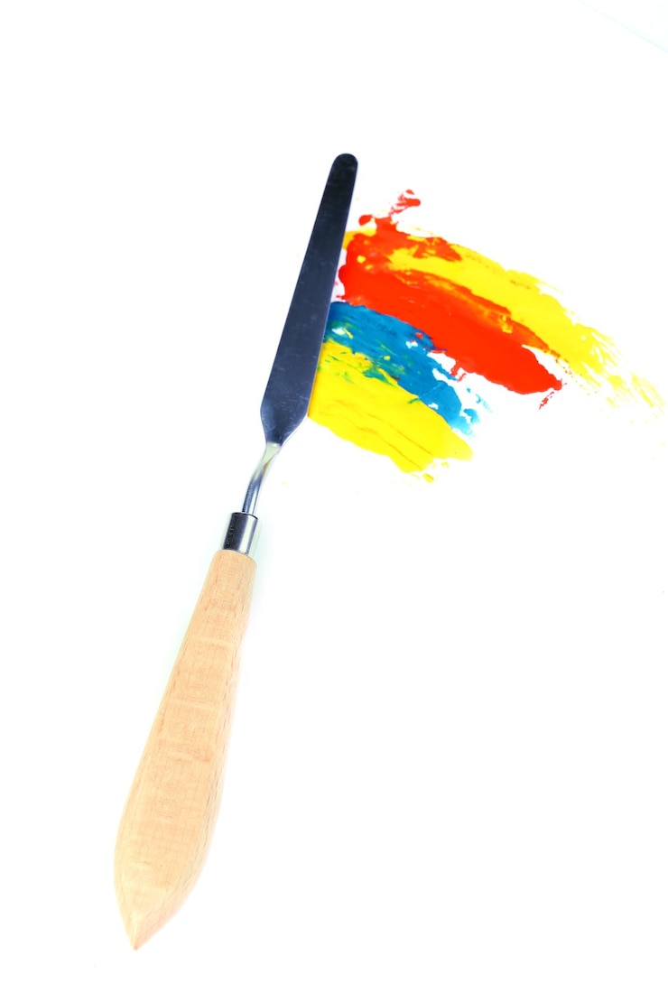 Photo couteau à palette de peinture avec des peintures isolées sur blanc