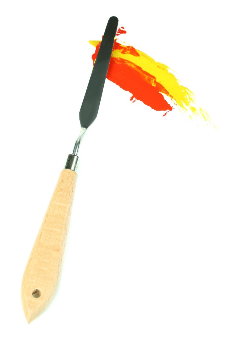 Photo couteau de palette de peinture avec des peintures isolées sur blanc