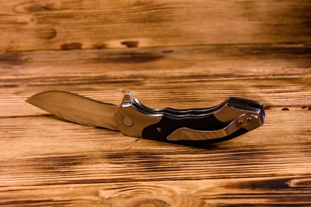 Couteau pliant ouvert sur une table en bois