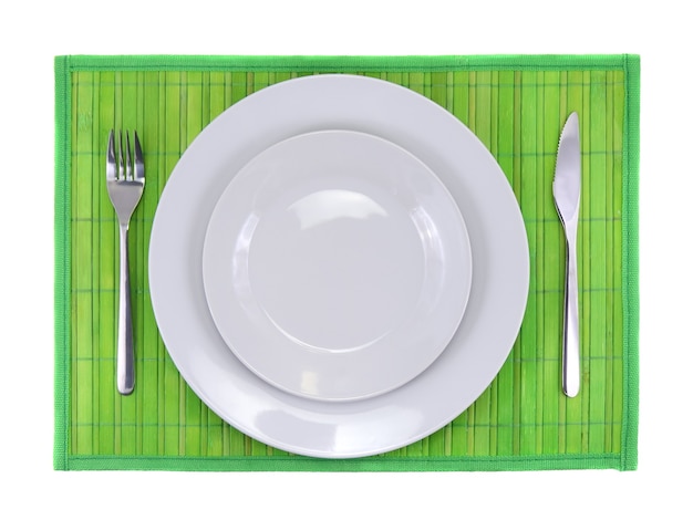 Couteau de service de table, assiette, fourchette sur fond de couleur verte.